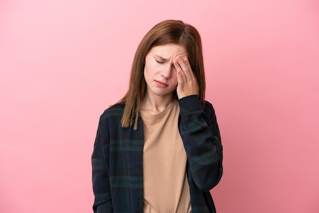 Jovem inglesa isolada em fundo rosa com dor de cabeça