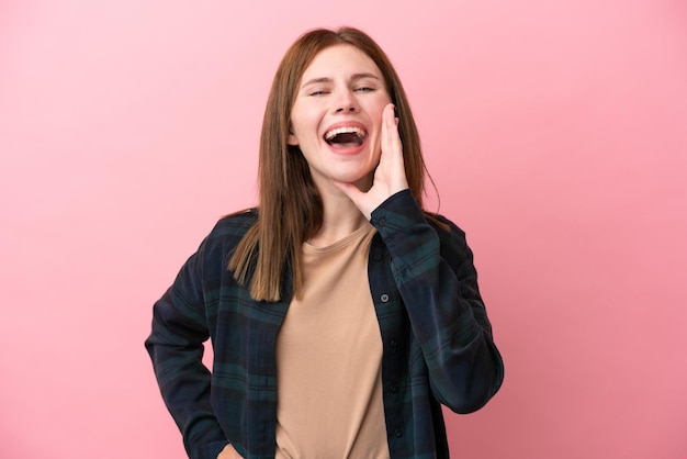 Jovem inglesa isolada em um fundo rosa gritando com a boca bem aberta