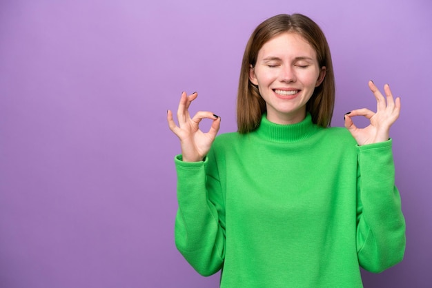 Jovem inglesa isolada em um fundo roxo em pose zen