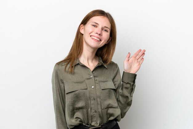 Foto jovem inglesa isolada no fundo branco saudando com a mão com expressão feliz
