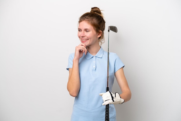 Jovem inglesa jogando golfe isolada no fundo branco, olhando para o lado e sorrindo