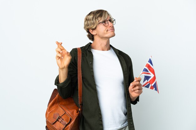 Jovem inglesa segurando uma bandeira do Reino Unido com os dedos cruzados e desejando o melhor