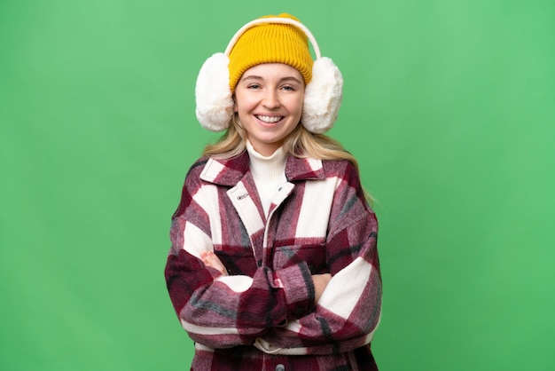 Jovem inglesa vestindo regalos de inverno sobre fundo isolado, mantendo os braços cruzados na posição frontal