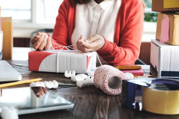 Jovem iniciante empreendedor pequeno empresário trabalhando em casa, embalagem e situação de entrega.