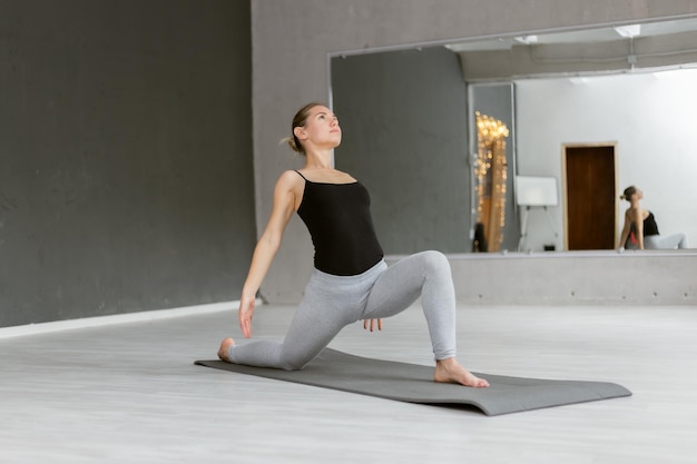 Jovem iogue atraente praticando ioga hatha Fazendo ioga interior no tapete Estilo de vida saudável