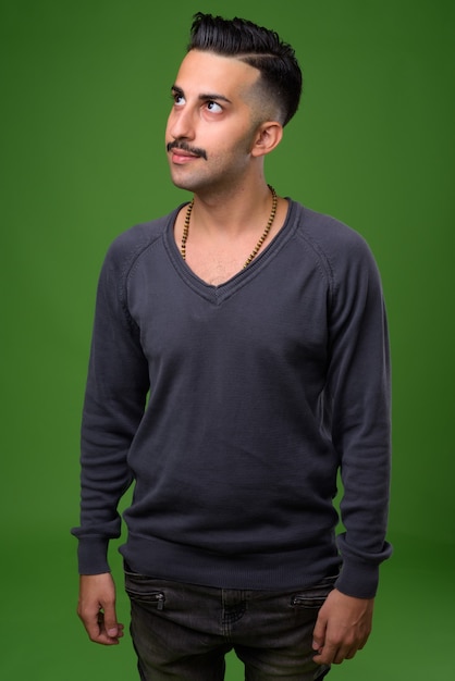 Jovem iraniano bonito com bigode verde