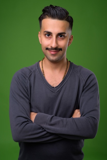 Jovem iraniano bonito com bigode verde