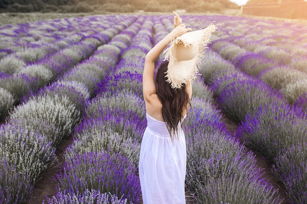 Jovem irreconhecível em pé no campo de lavanda. Senhora no verão