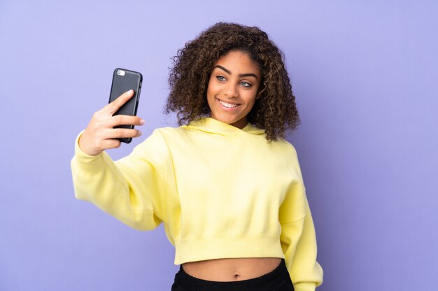 Jovem isolada na parede, fazendo um selfie