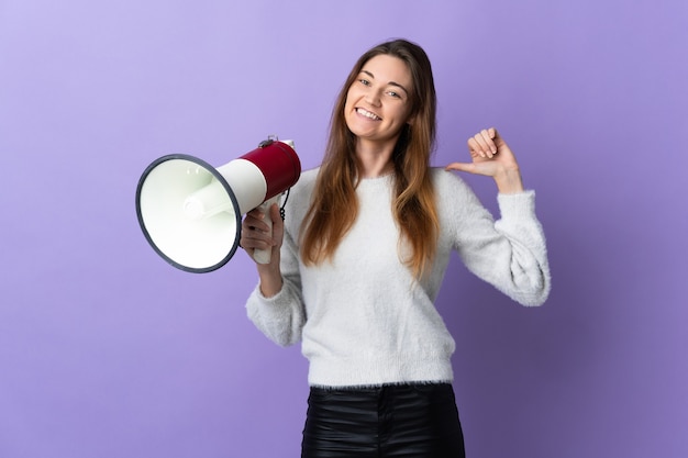 Jovem isolada na parede roxa segurando um megafone orgulhosa e satisfeita