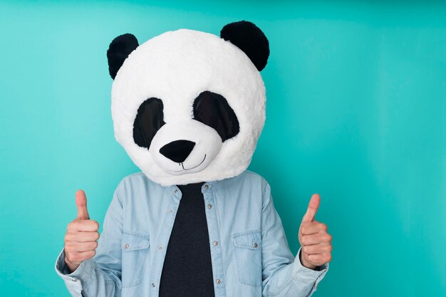 Jovem isolado com máscara de panda fazendo gesto de polegar para cima