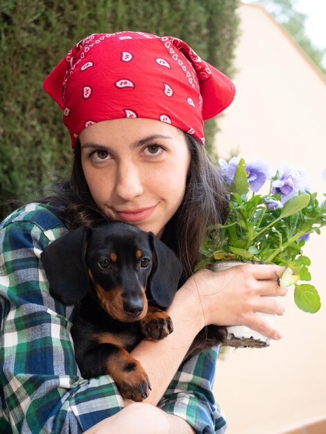 Jovem jardinagem em casa com seu cachorrinho teckel