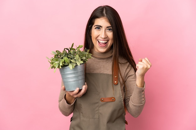 Jovem jardineira segurando uma planta isolada