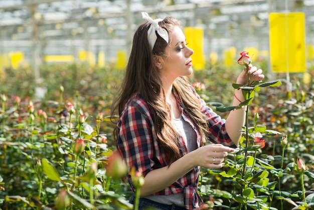 Jovem jardineiro ou trabalhador de estufa cuida de flores na estufa