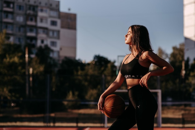 Jovem jogadora de basquete jogando bola de rua