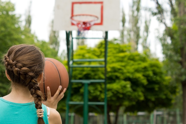 jovem jogadora de basquete mirando com a bola