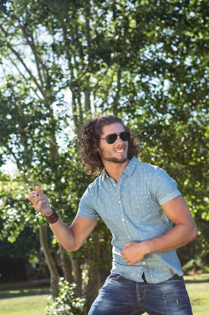 Jovem jogando ar guitarra no parque