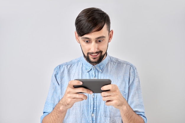 Jovem jogando em smartphone isolado