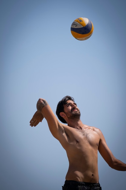 jovem jogando vôlei de praia em um dia ensolarado