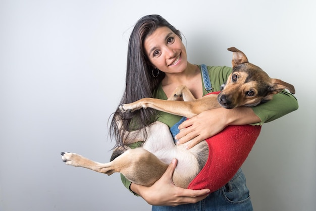 Jovem latina com seu cachorro adotado nos braços cachorrinho animal