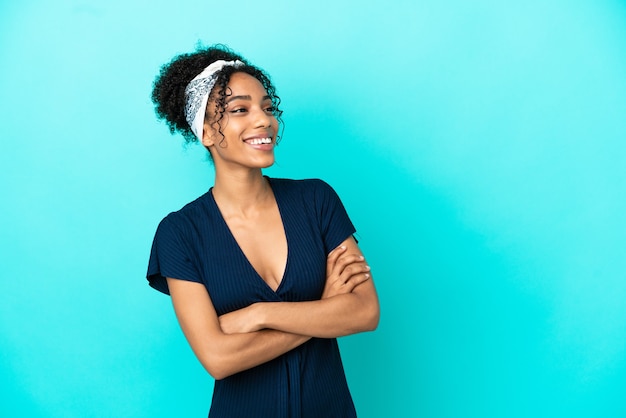 Jovem latina isolada em um fundo azul feliz e sorridente