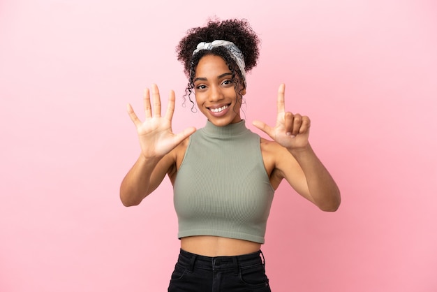 Foto jovem latina isolada em um fundo rosa contando sete com os dedos
