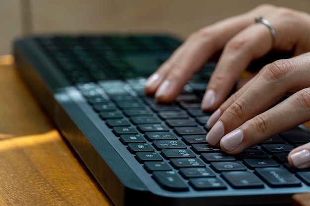 Jovem latina mexicana digitando em um teclado sem fio em seu computador