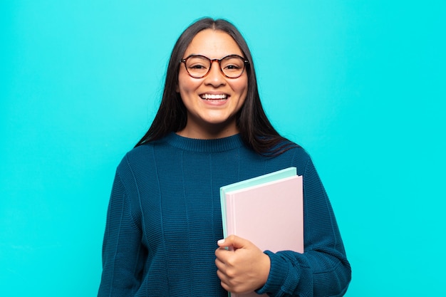 Jovem latina parecendo feliz e agradavelmente surpresa, animada com uma expressão de fascínio e choque