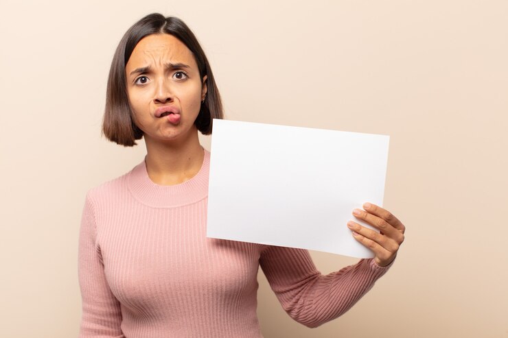 Foto jovem latina parecendo perplexa e confusa, mordendo o lábio com um gesto nervoso, sem saber a resposta para o problema