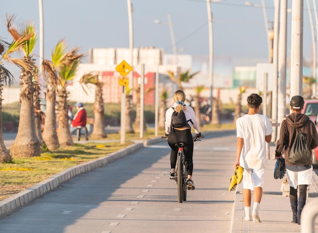 jovem latina pedalando em uma ciclovia ao pôr do sol