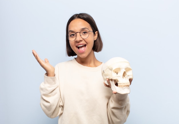 Jovem latina se sentindo feliz, animada, surpresa ou chocada, sorrindo e atônita com algo inacreditável