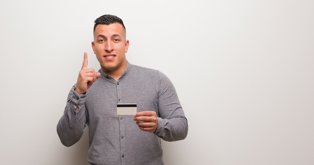 Jovem latina, segurando um cartão cit mostrando o número um