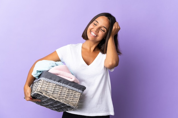 Jovem latina segurando uma cesta de roupas