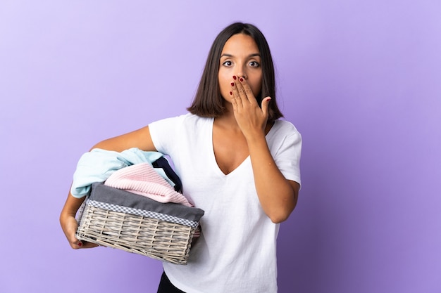 Jovem latina segurando uma cesta de roupas