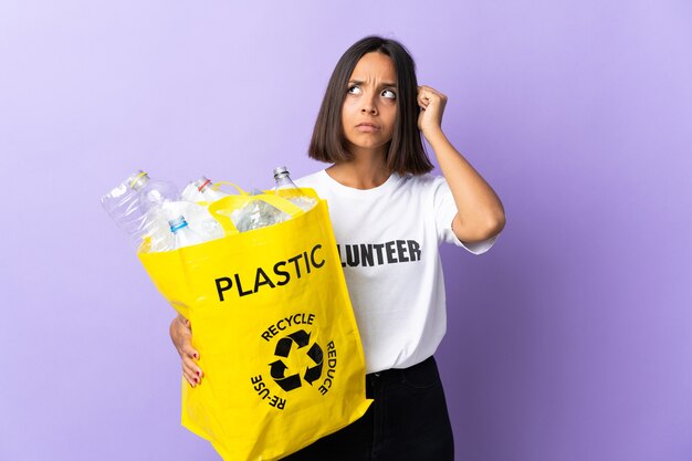 Jovem latina segurando uma sacola de reciclagem cheia de papel para reciclar