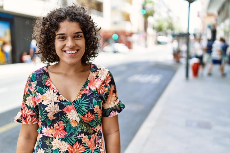 Foto jovem latina sorrindo feliz em pé na cidade