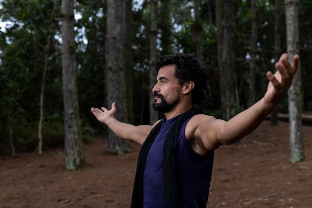 Jovem latino-americana 37 dentro de uma floresta de pinheiros com os braços abertos para o céu celebrando a liberdade Conceito emoções humanas positivas e percepção da vida