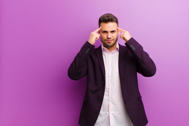 Jovem latino-americano, com um olhar sério e concentrado, fazendo brainstorming e pensando em um problema desafiador