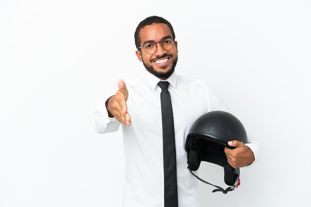 Jovem latino de negócios com capacete de motociclista isolado no fundo branco apertando as mãos para fechar um bom negócio