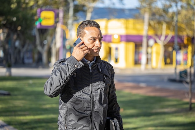 Jovem latino falando no celular com espaço de cópia