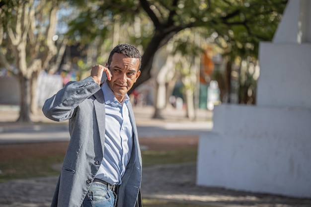 Jovem latino falando no celular visto por trás