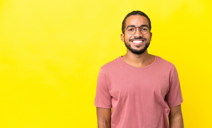 Foto jovem latino isolado no fundo amarelo rindo