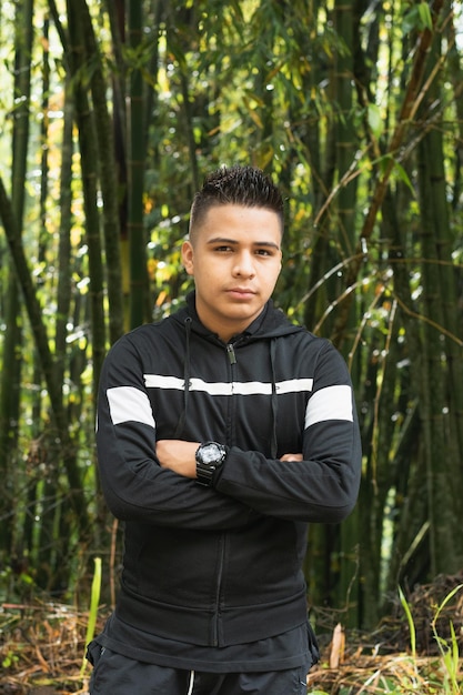 Jovem latino no meio de uma bela floresta de bambu nas majestosas montanhas colombianas