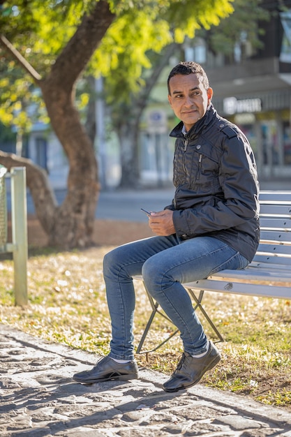 Jovem latino sentado em um banco quadrado