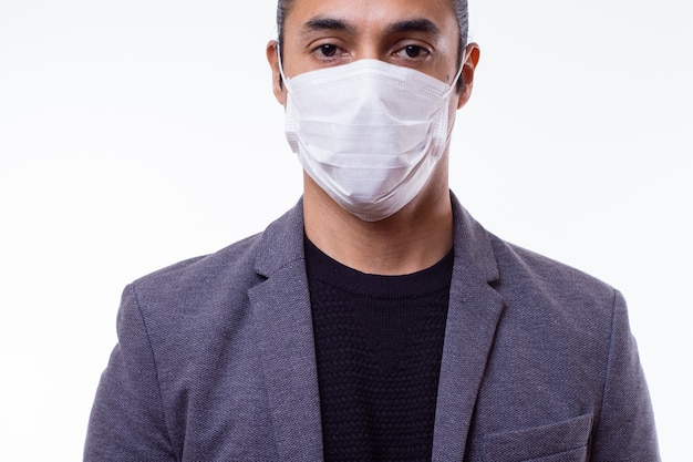 Jovem latino usando uma máscara médica em branco