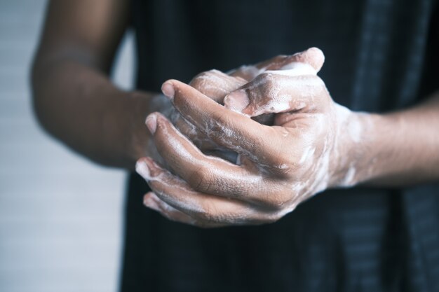 Foto jovem lavando as mãos com água morna e sabão