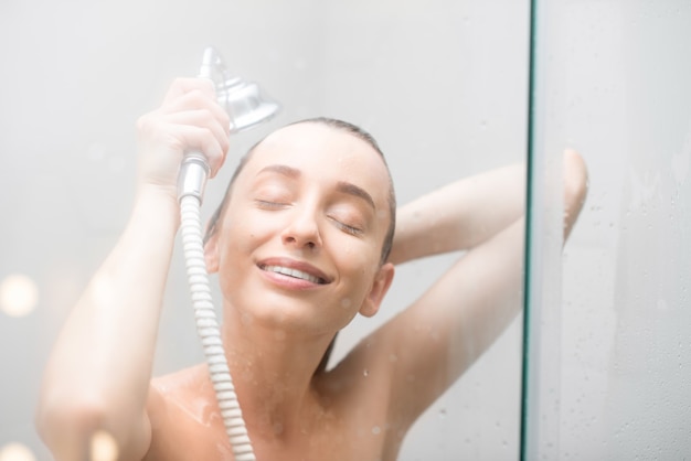 Jovem lavando cabelo no chuveiro