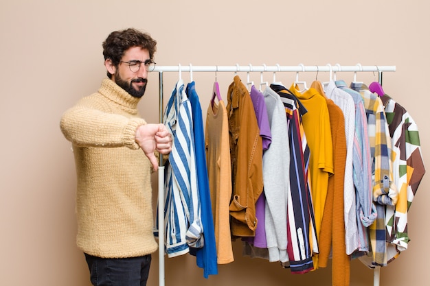 Jovem legal homem com roupas contra a parede plana