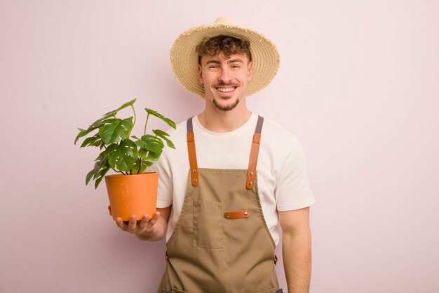 Jovem legal olhando jardineiro e planta feliz e agradavelmente surpreso