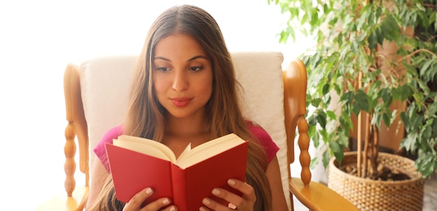 Foto jovem lendo um livro em casa